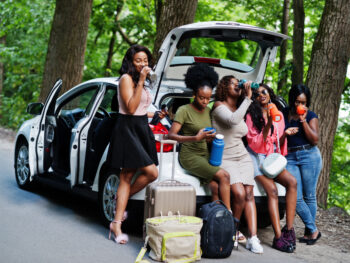 friends hanging out and eating road trip food they packed for their trip