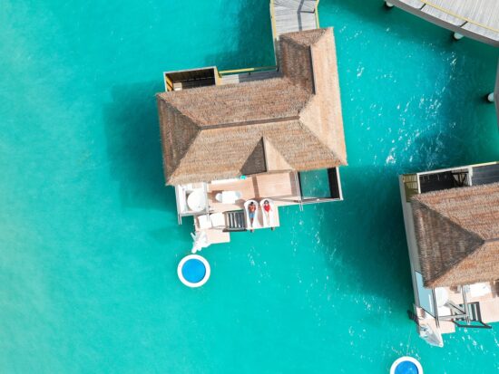 drone photo of couple sitting on overwater bungalows in jamaica at sandals south coast