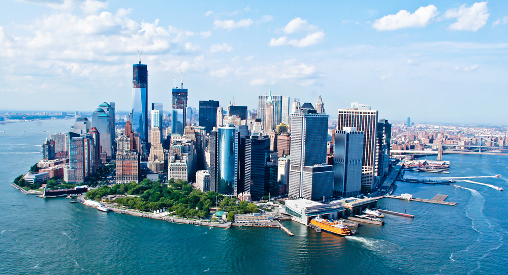 The island of Manhattan, the famous New York City Skyline, surrounded by water on a sunny day