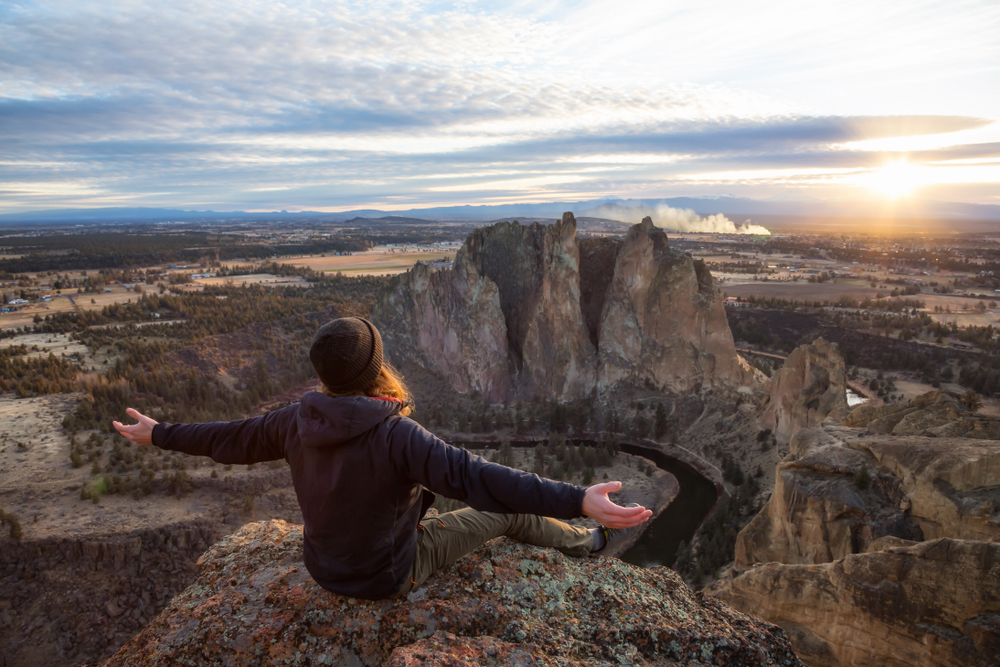 Person with long hair sitting on top of Misery Ridge at Smith Rock State Park in Oregon