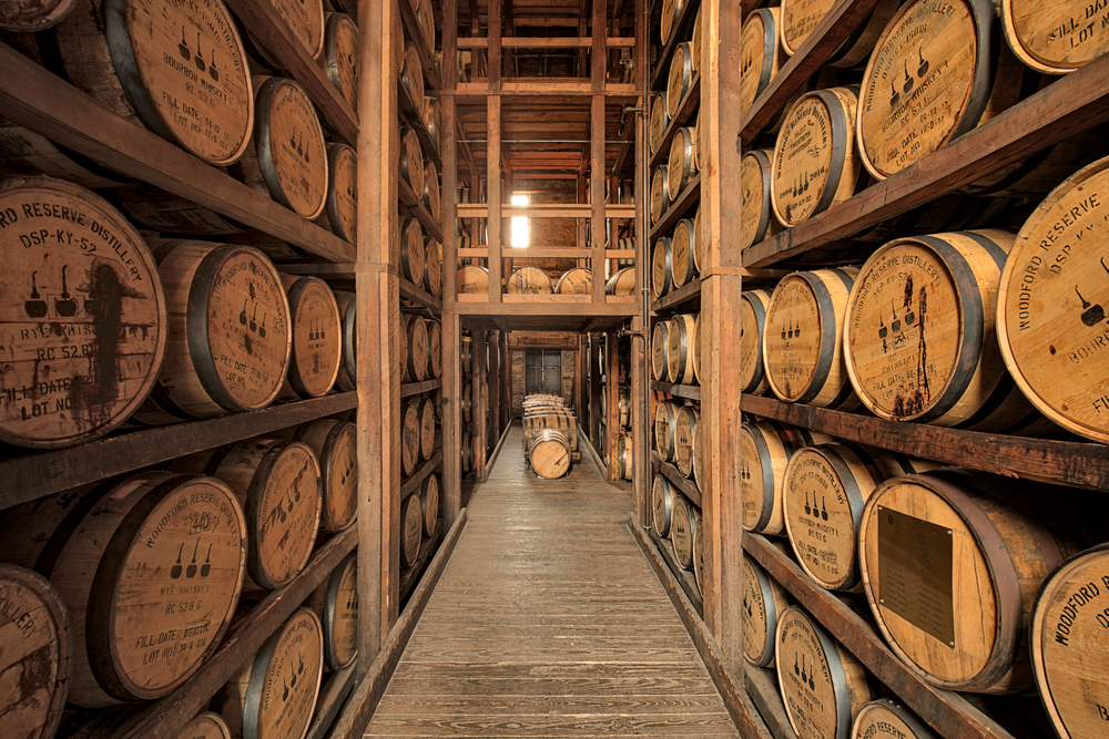 A room full of shelves with barrels of bourbon stacked on top of each other at Woodford Reserve Distillery on an East Coast road trip.