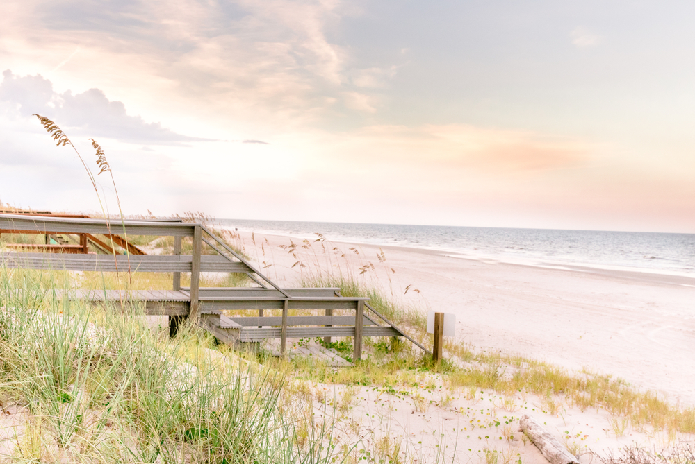 The sand dunes and a wooden walkway over them leading to the shore of the ocean at Amelia Island.