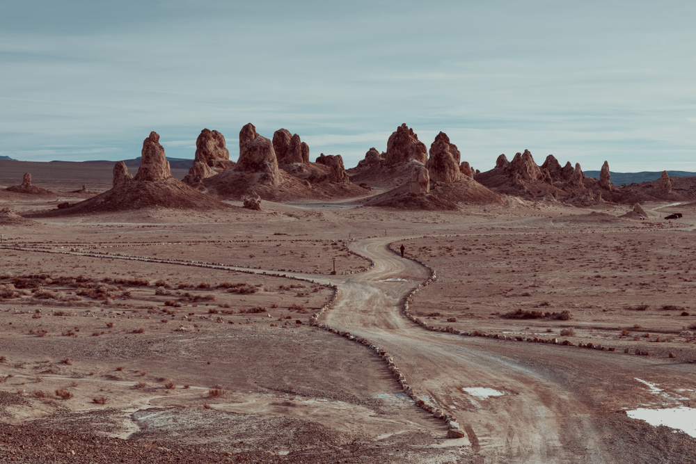 A dirt road in the middle of the desert that leads to the Trona Pinnacles. The Trona Pinnacles are large rock formations randomly in the middle of the desert.