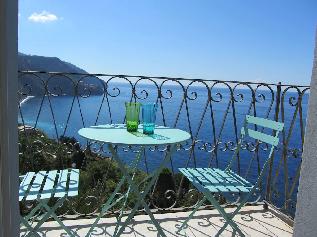 blue chairs on a balcony in corniglia overlooking the ocean in cinque terre italy