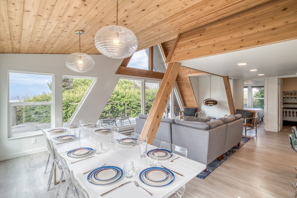 Cool vitage lighting and exposed wood make a statement in the dining area of this retro A frame, one of the best vacation rentals on the Oregon Coast. The table in the photo is set for 10, you could have a great party here! 