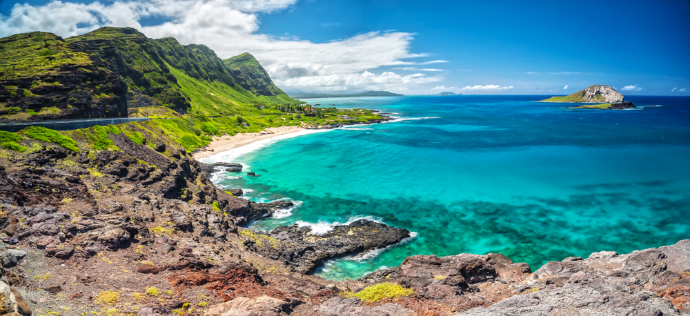 A view of large mountains on the edge of the crystal blue Pacific Ocean in Oahu, Hawaii, one of the best islands in the USA.  