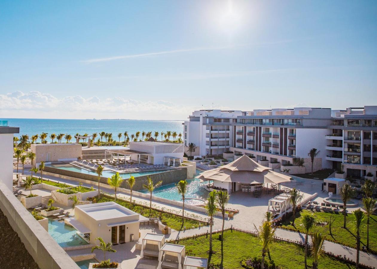 The grounds of a large all-inclusive resort in Mexico that has multiple pools, grassy areas, beaches, and large suites. 