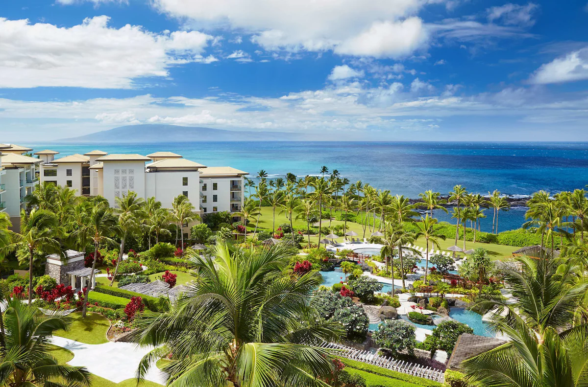 Aerial view of a hotel by the sea showing buildings and a pool