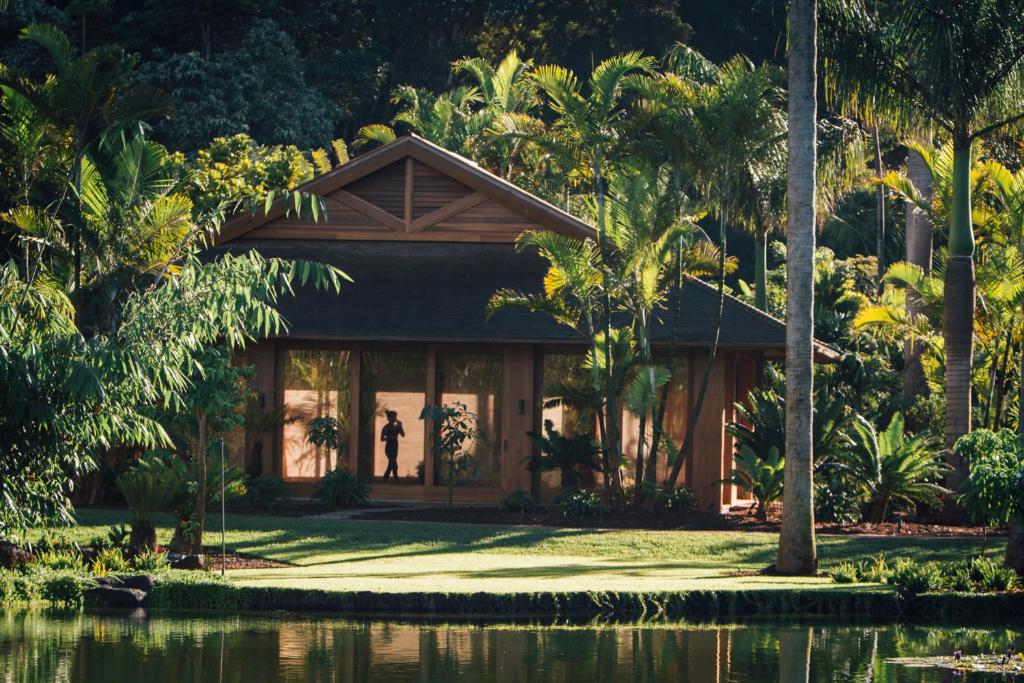 Wooden hotel cabin among lush vegetation in and article about the best luxury hotel in Hawaii