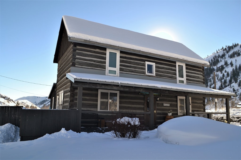 the picturesque log cabin covered in snow