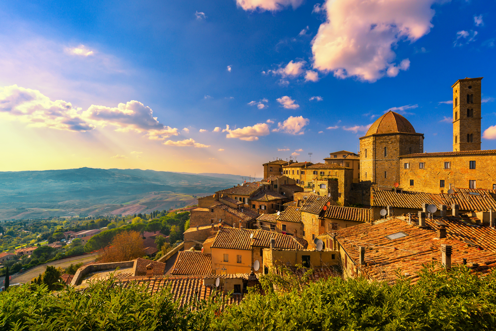 Beautiful old town of Volterra tucked on a hillside at golden hour.