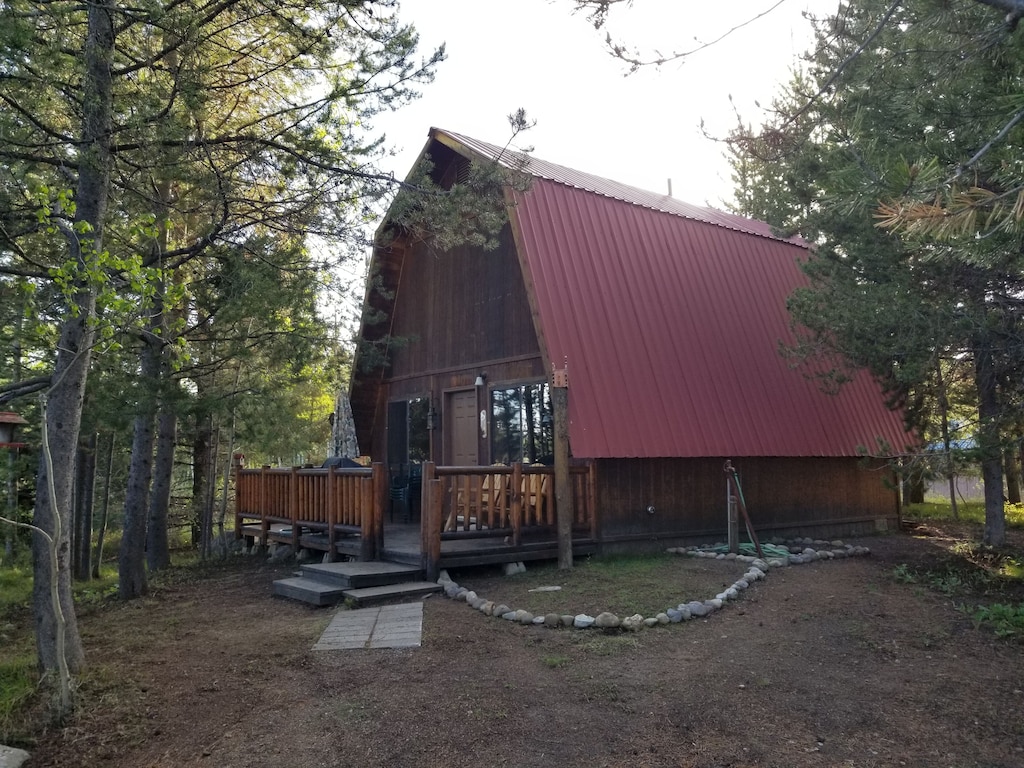 exterior of this barn shaped cabin in idaho with a red metal roof.