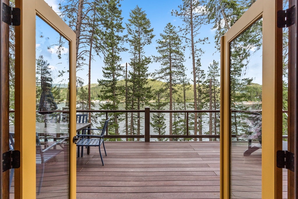 view of the pine trees and lake beyond of this cheerful lake cabin in Idaho 