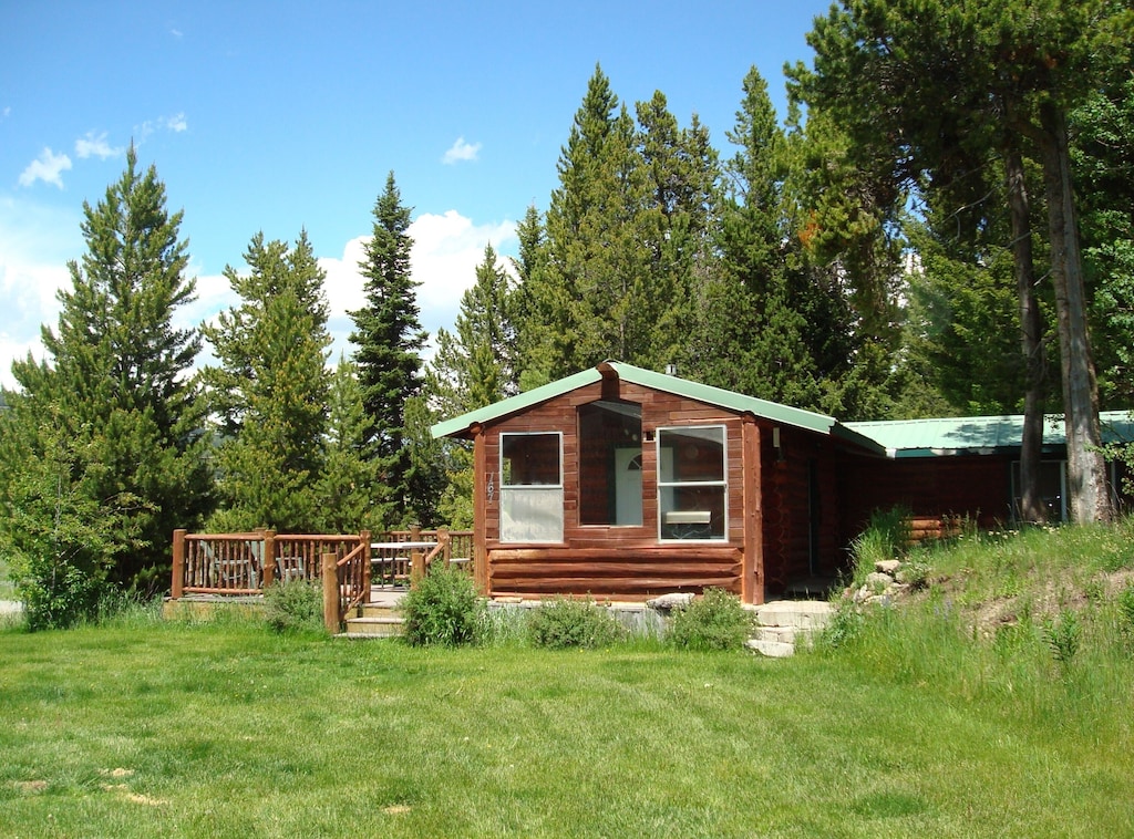 the classic log cabin and green metal roof exterior of the Yellowstone Cabin. 