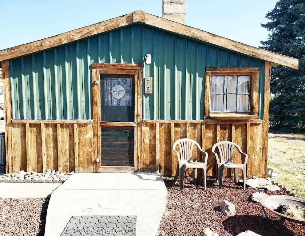 exterior of this small green and wood paneled cabin