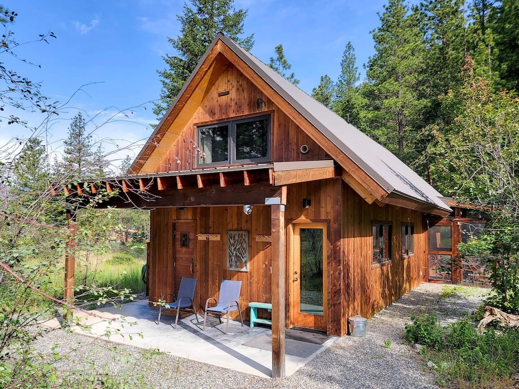 View of the sweet wooden cabin surrounded by pine trees.