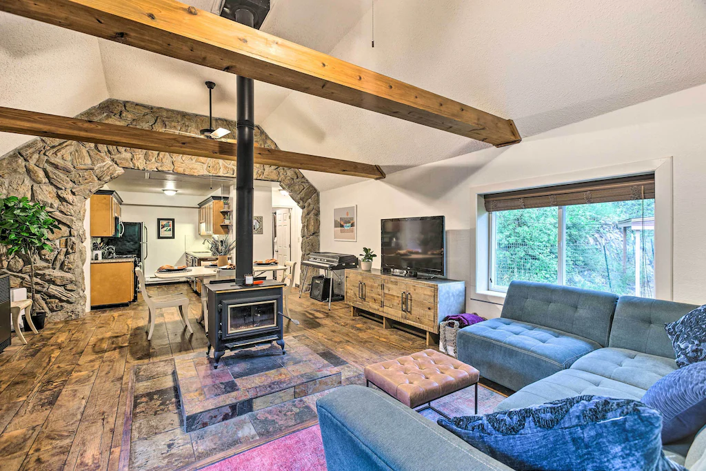 Inside of one of the best cabins in colorado showing the fron room with a large sofa and wood buring fire