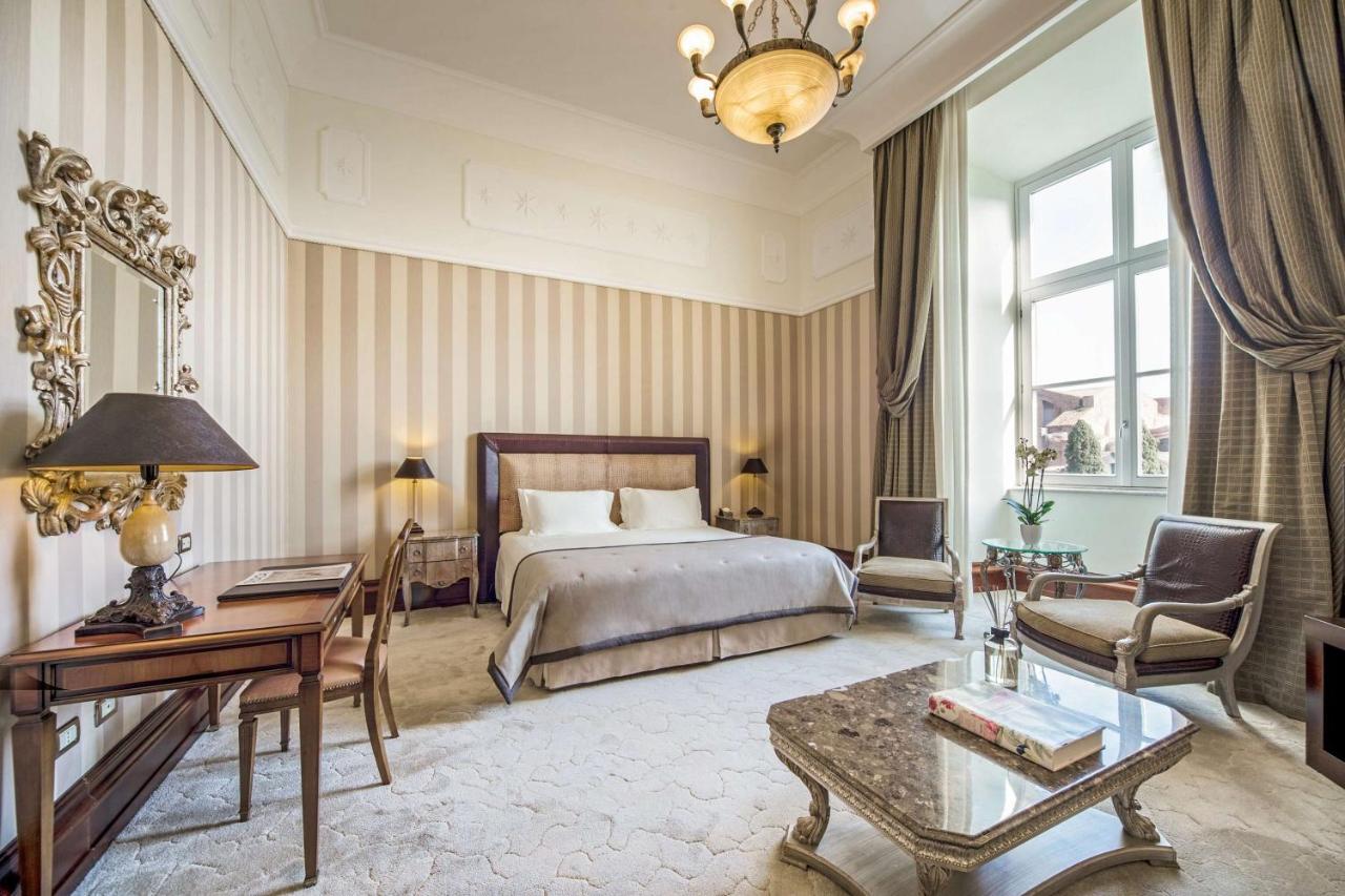 Large and elegant room at Anantara Palazzo Naiadi with plush carpet and a big window.