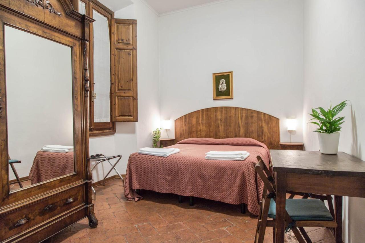 Simple yet cozy room at the Casa Santo Nome di Gesu with a big mirror.