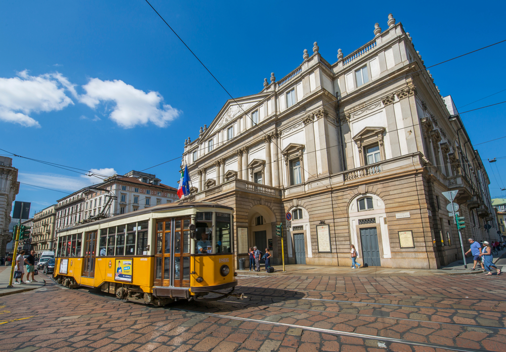 Yellow tram passing in front of the opera house in Centro Storico.