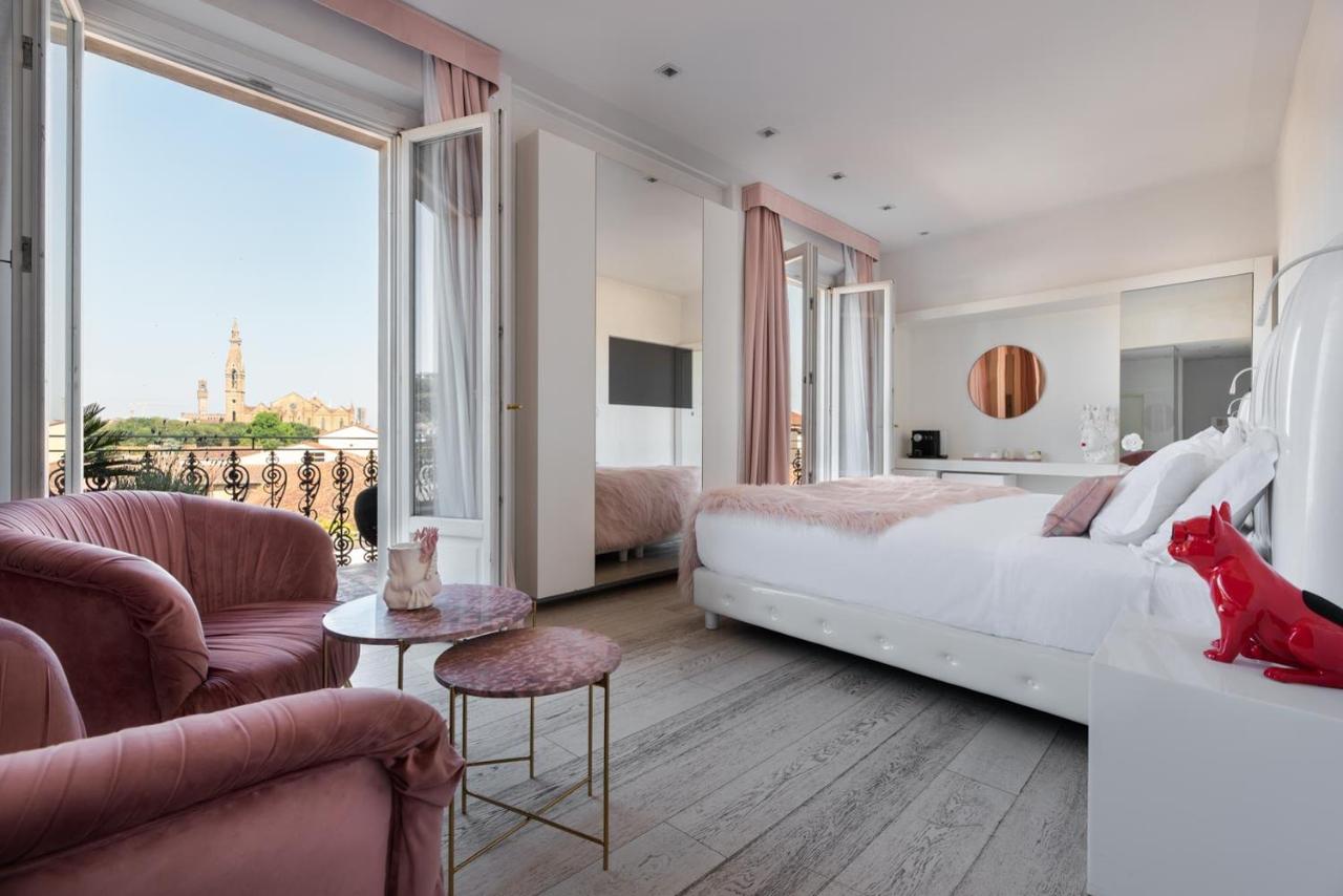 Big room at the Eurostars Florence Boutique with pink accents and open doors leading to a balcony.