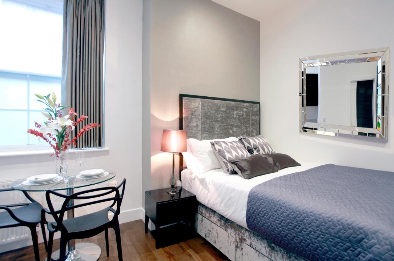 Modern bedroom at Golden Square with table and big mirror.