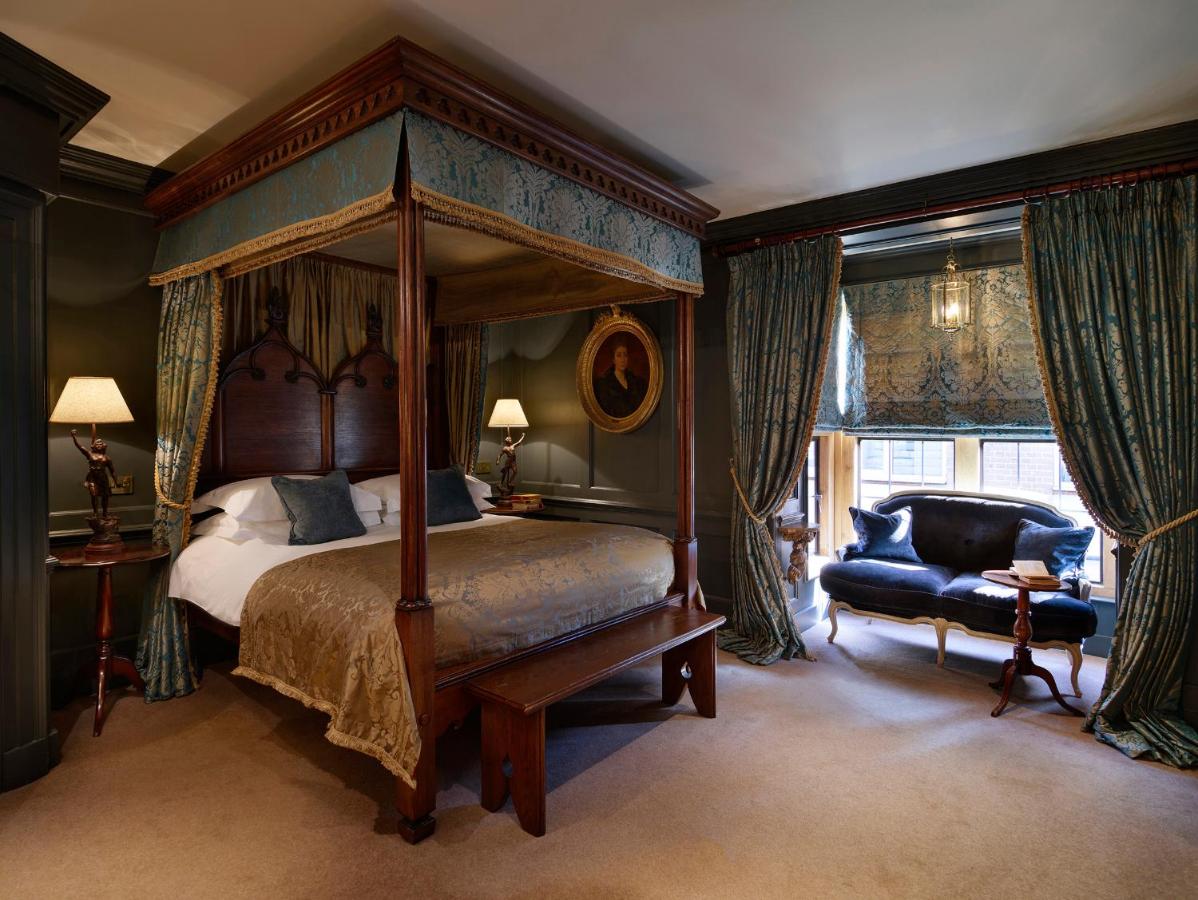 Dark and elegant room at Hazlitt's with a canopy bed and window seating.