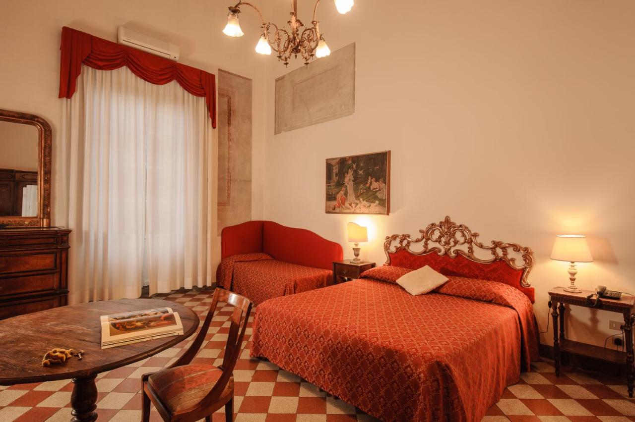 Room at Hotel Annalena with a red bed and sofa.