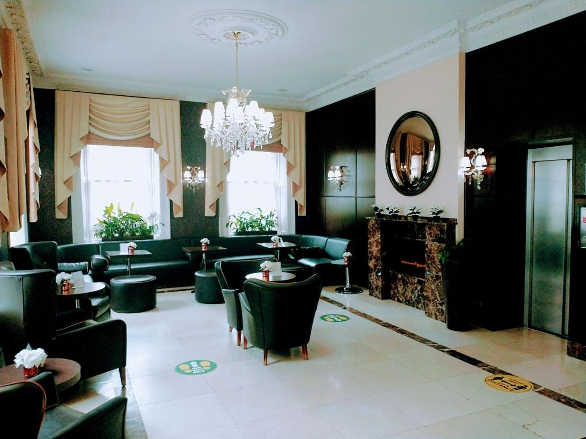 Elegant entry to the Hotel Edward Paddington with black furniture and chandelier.
