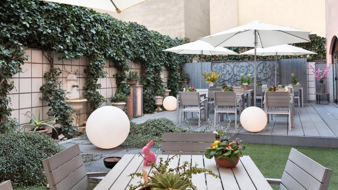 The garden terrace at Hotel Lombardia with seating and an ivy wall.