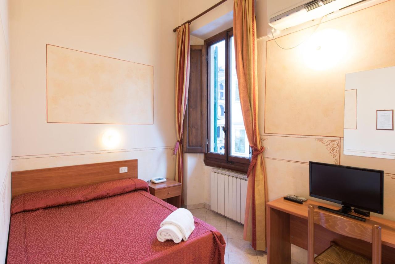 Simple room at the Hotel Palazzuolo with a queen-sized bed and window.