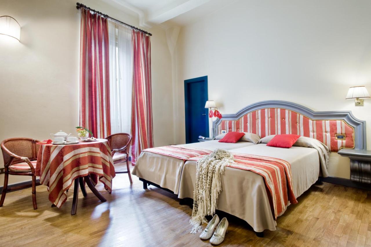 Nice room at the Hotel Unicorno with red and white accents and a table with tea.