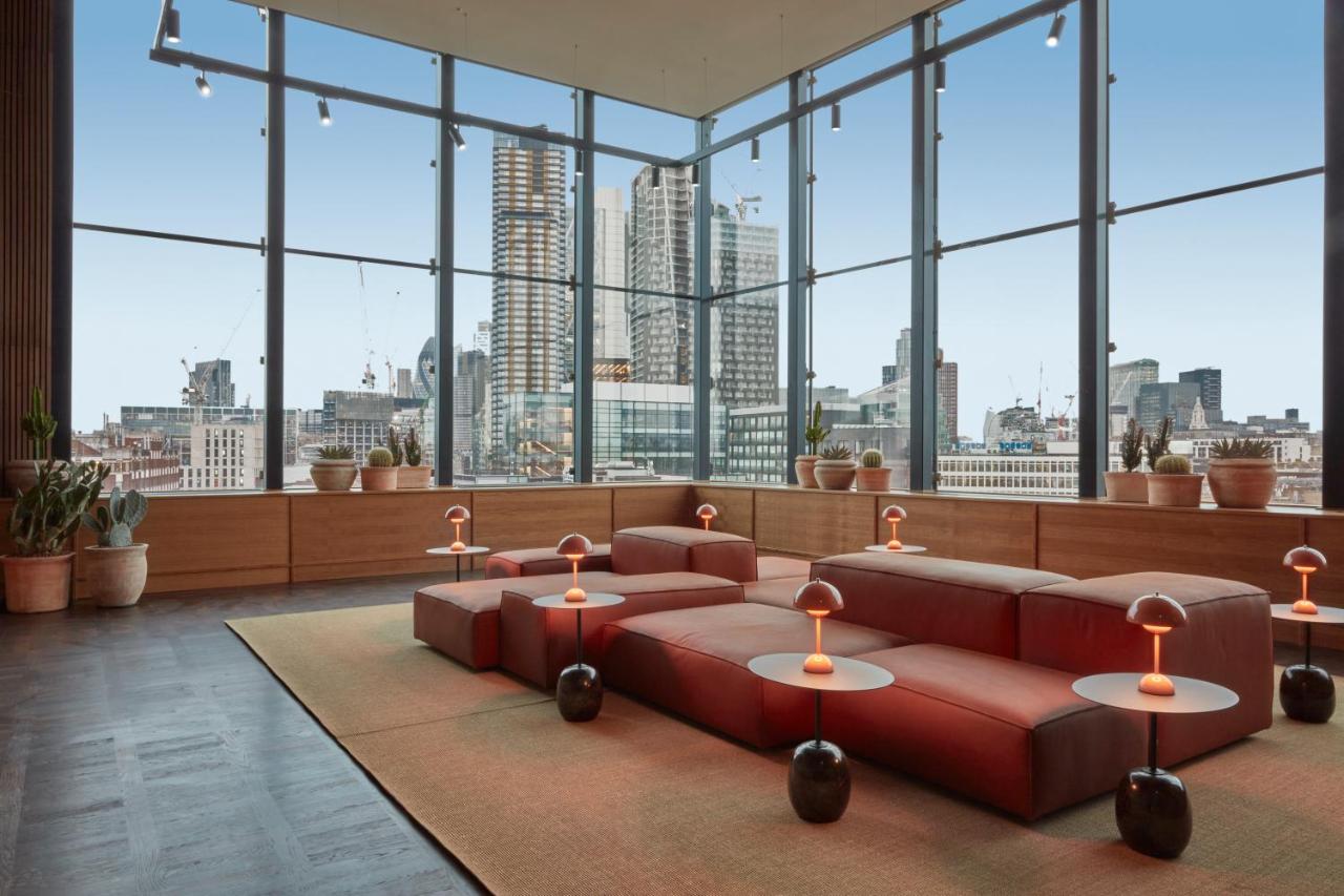 Modern sitting area in One Hundred Shoreditch with floor to ceiling windows looking out to the skyline.