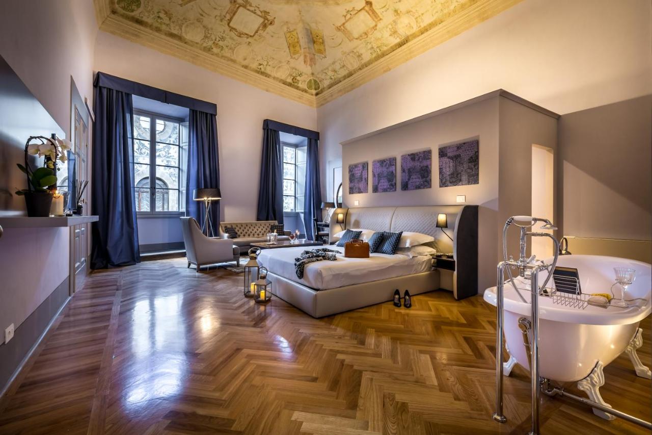 Spacious room at the Palazzo Ridolfi - Residenza d'Epoca with bath tub, big bed, and sitting area.
