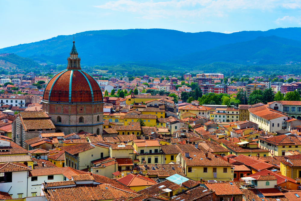 View of the rooftops of Pistoia with mountains in the distance, a great Tuscany road trip stop.
