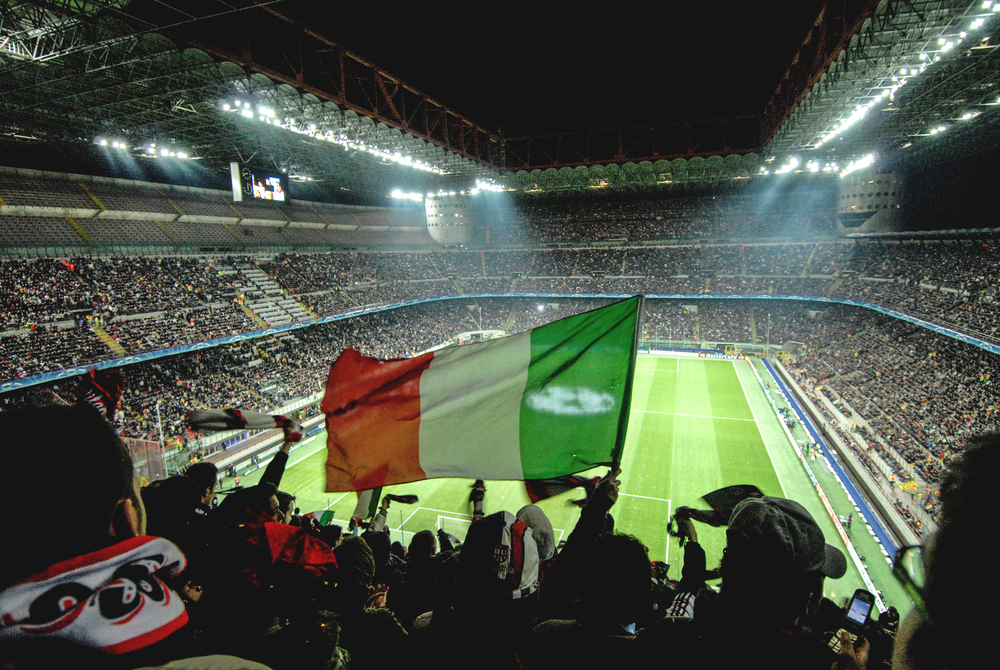 Italian flag waving in the stands of Siro Stadium in Milan.