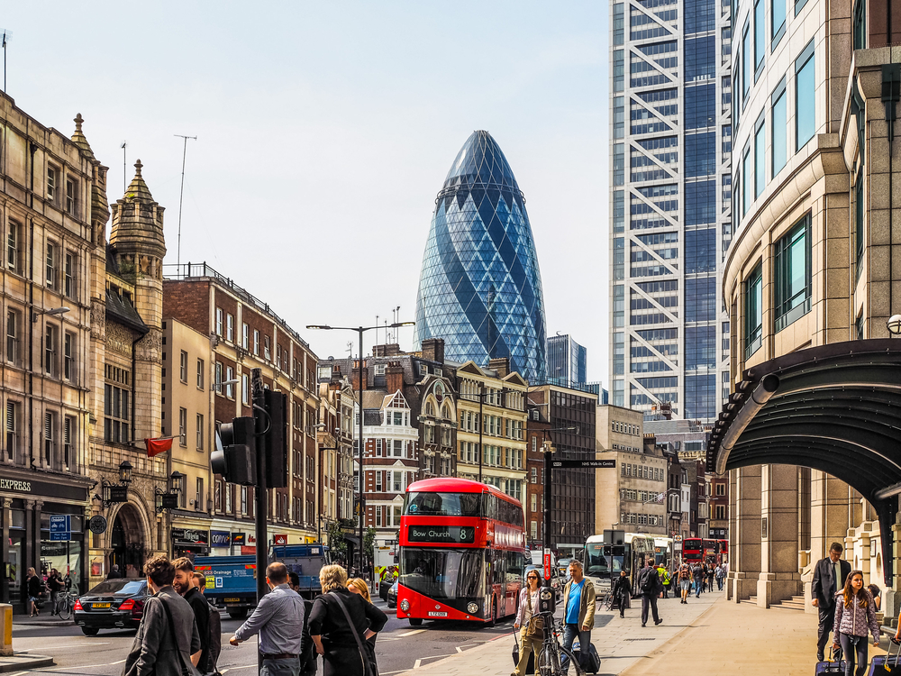 People walking around the Shoreditch High Street with the Shard building in the distance.