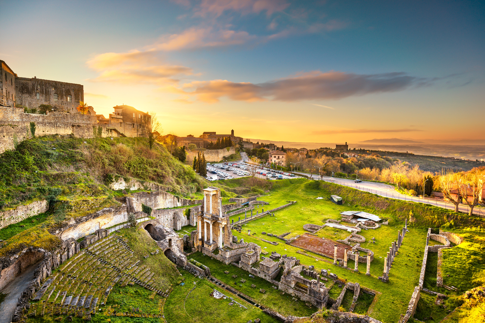 The ruins of the Roman Theater at sunset see on a Tuscany road trip.