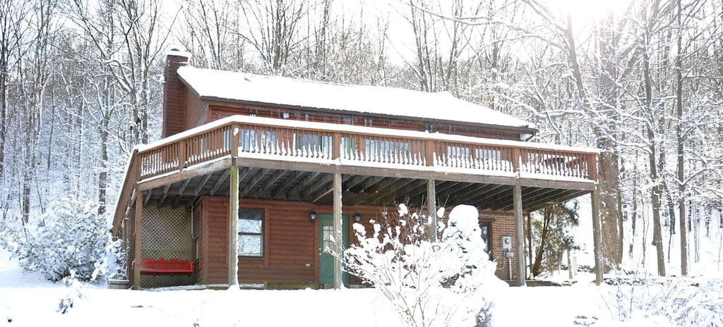 View of the exterior of the deep creek log cabin covered in snow. 