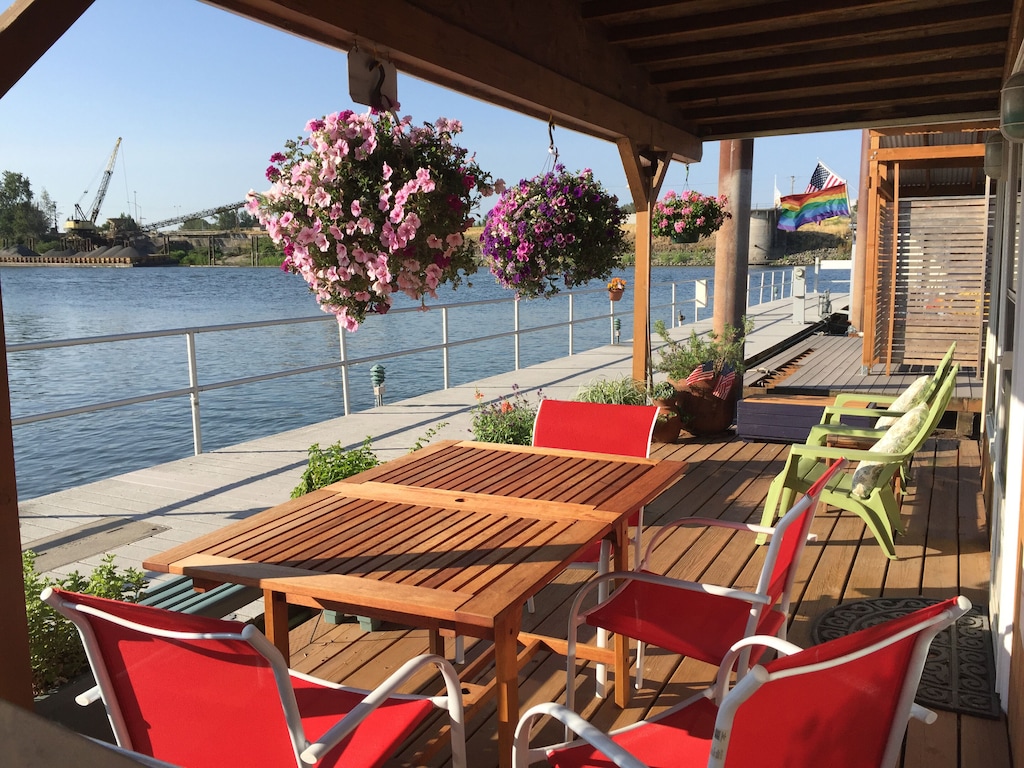 View of the spacious deck and hanging planters of this columbia river houseboat 