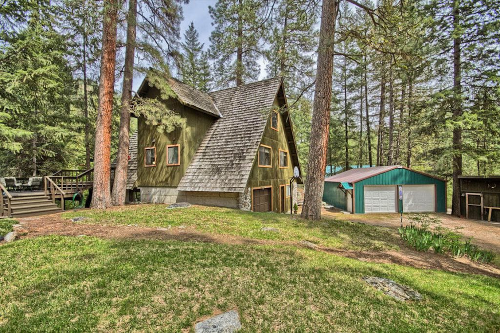 view of the olive green exterior and surrounding old growth pines at the dog friendly a frame in leavenworth