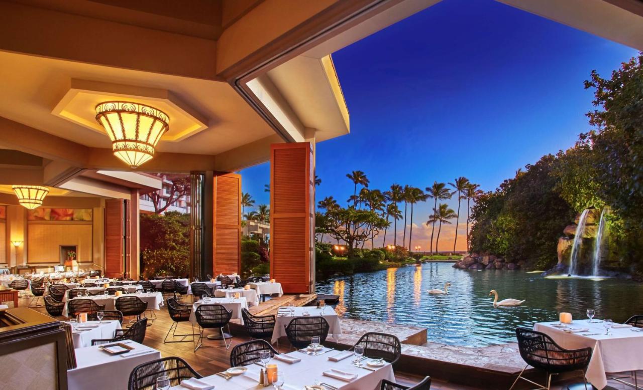 Outdoor seating at a restaurant with views of waterfall and pond.