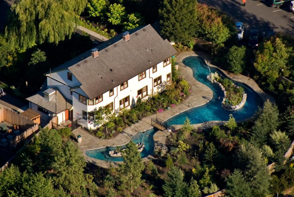 An aerial view of a historic mansion that is a resort with a looping lazy river style pool behind it