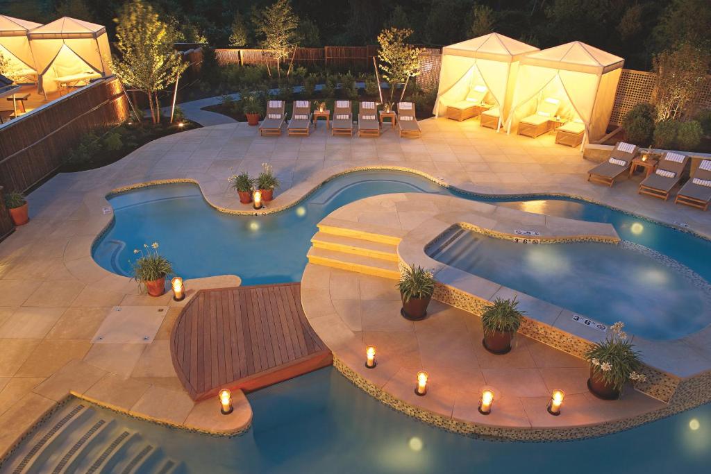 Free form swimming pool with a patio deck and lights around.  