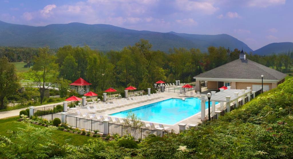 Hotel pool surrounded by greenary and mountains  