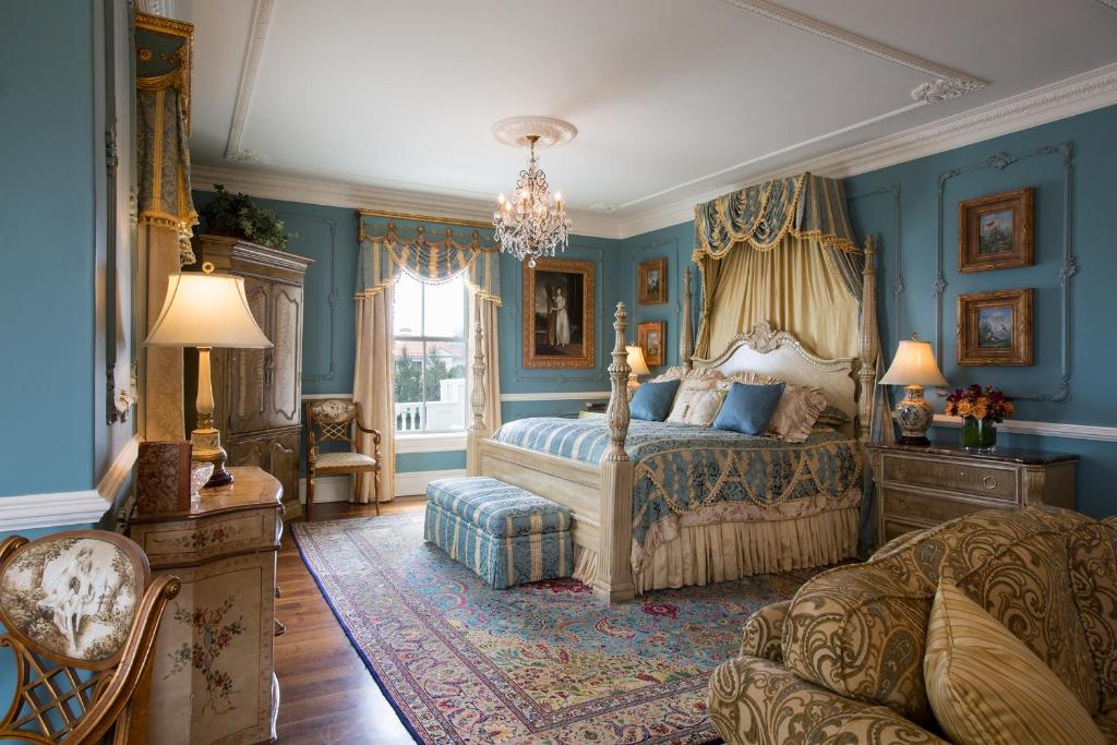 A beautiful hotel bedroom with a very vintage feel it is blue and gold. 