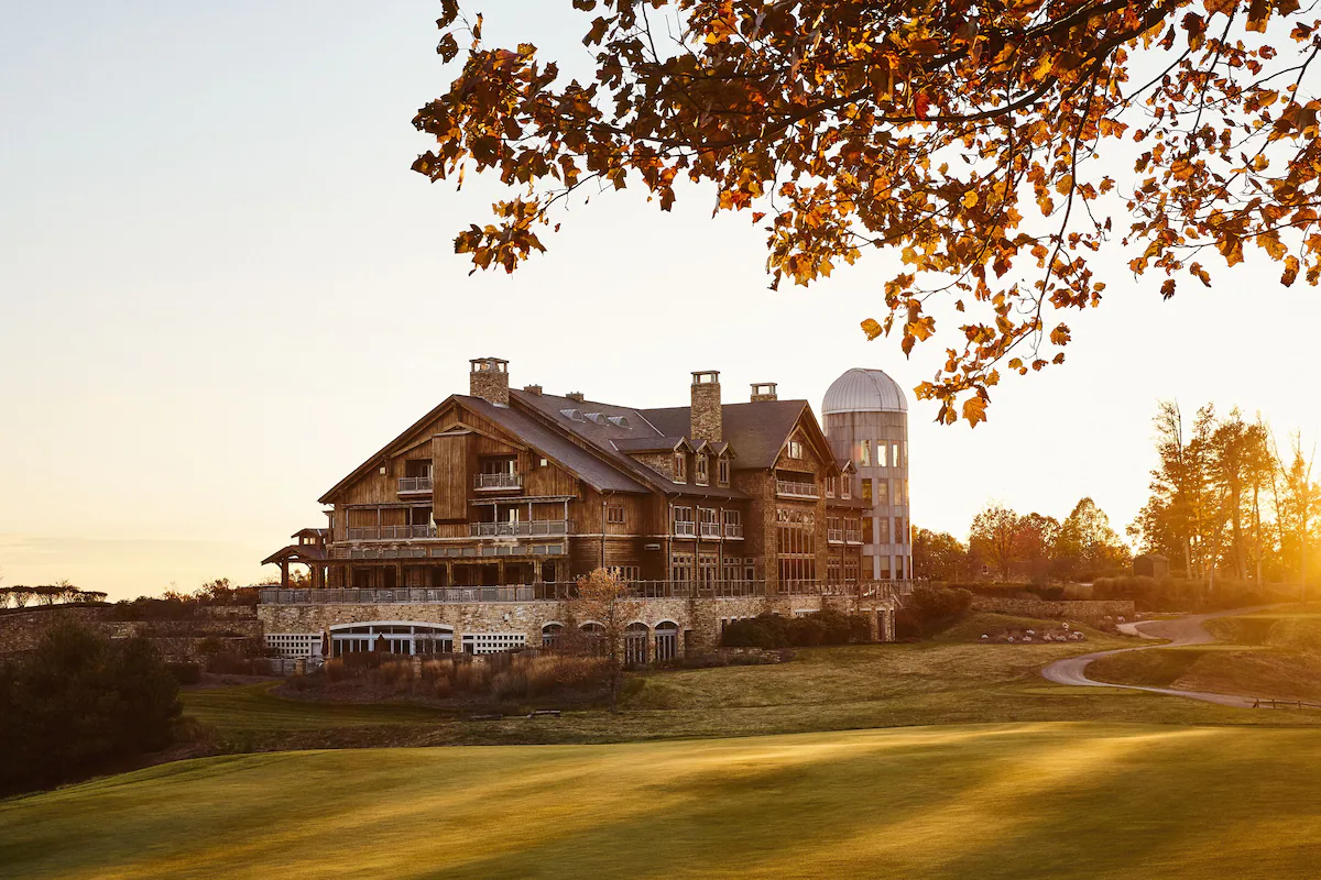 Photo of a hotel that looks like a lodge taken at sunset from the golf course