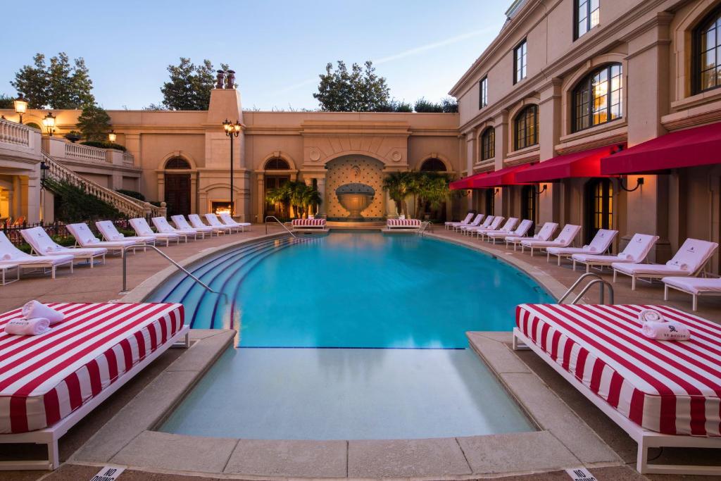 Beautiful hotel pool in an ornate pation surrounded by sunbeds with a fountin in the background. the article is about the best resorts on the East Coast 