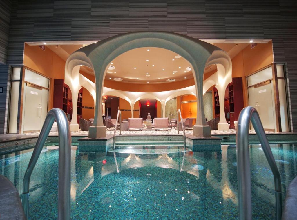 Ornate hotel pool with arches and seating area. 