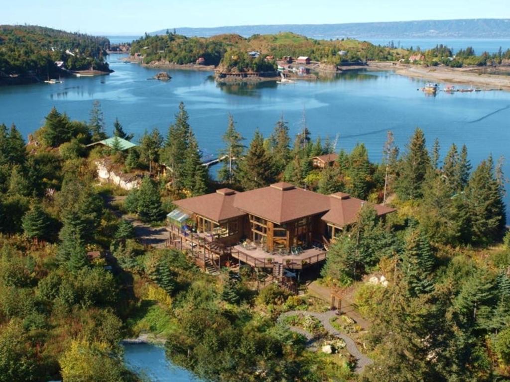 An aerial view of a resort on the edge of a lake surrounded by trees in a bay